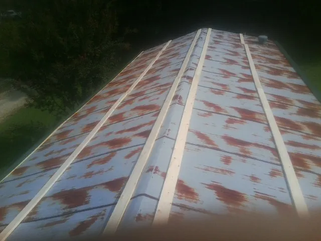 Rusted metal roof panels with new wood purlins before replacement — Storm Damage Roof Repair in El Mirage by Roofing Brothers